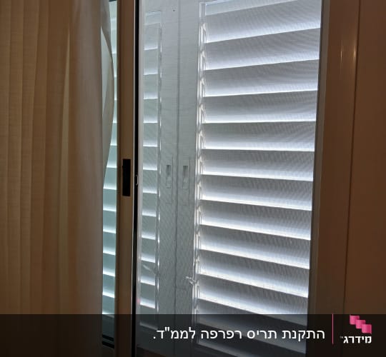 חלון אלומיניום עם תריסים סגורים ורשת